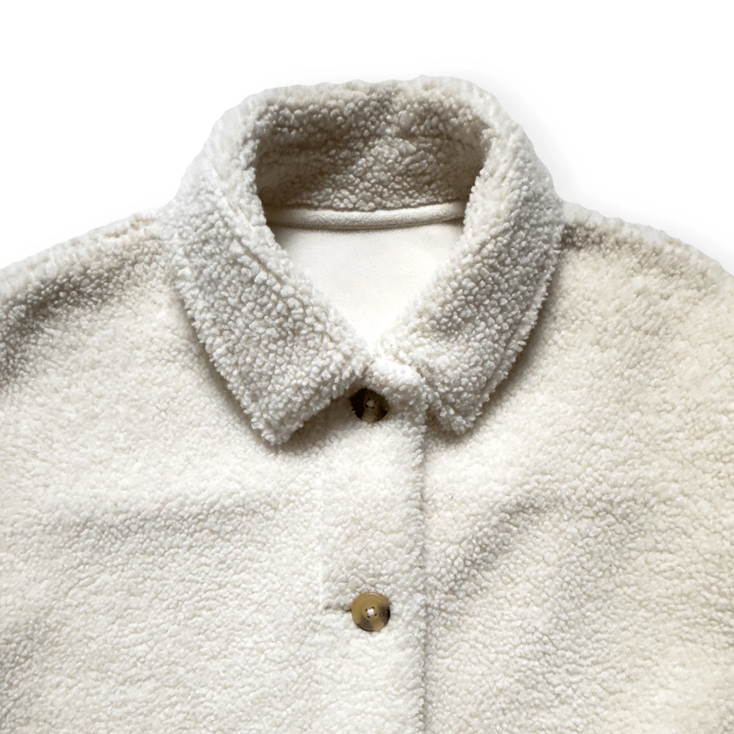 Close-up van de kraag en zachte teddytextuur van een pre-loved Uniqlo overshirt in ecru