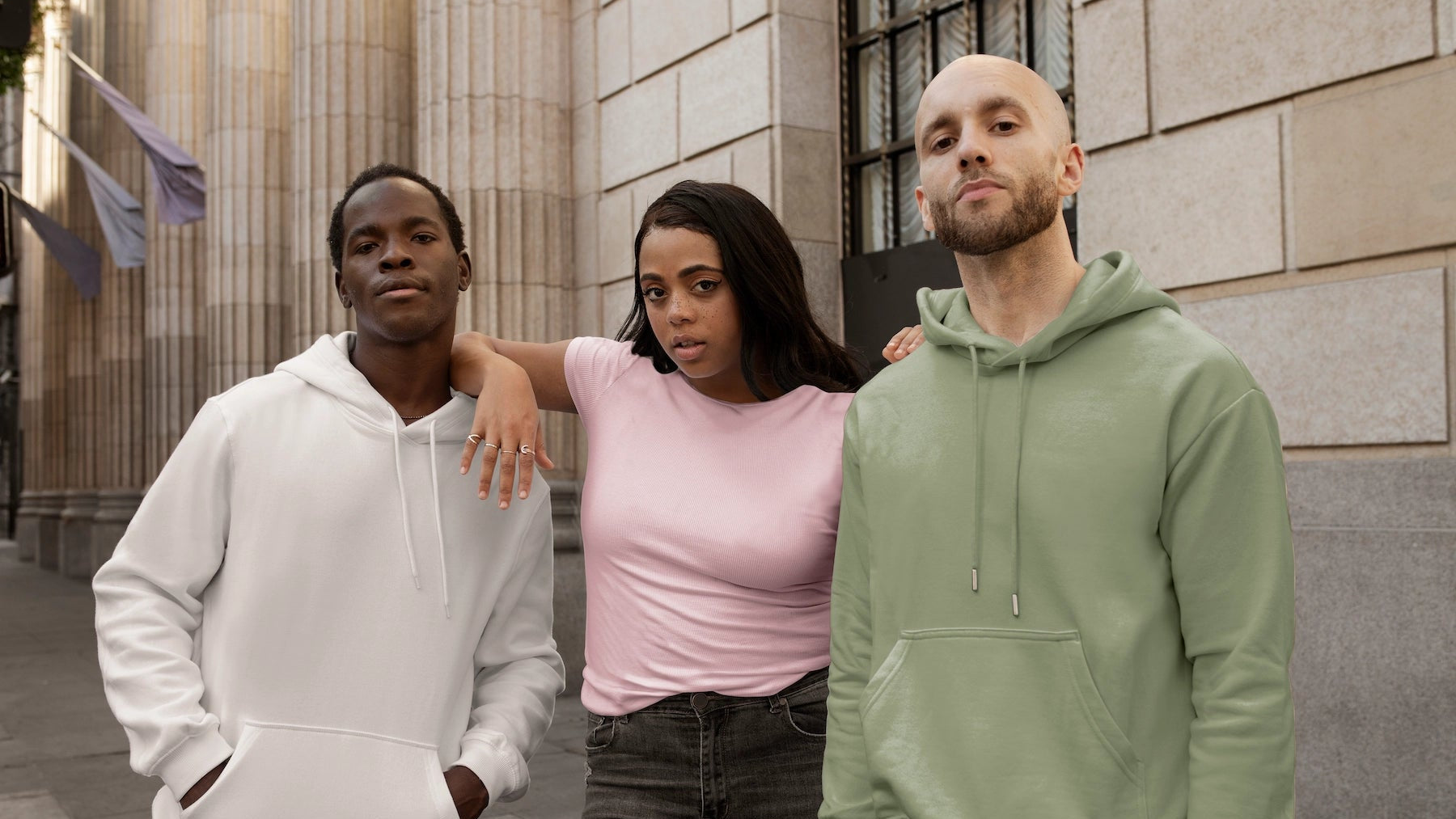 Drie modellen in casual hoodies en een T-shirt tijdens een streetstyle fotoshoot