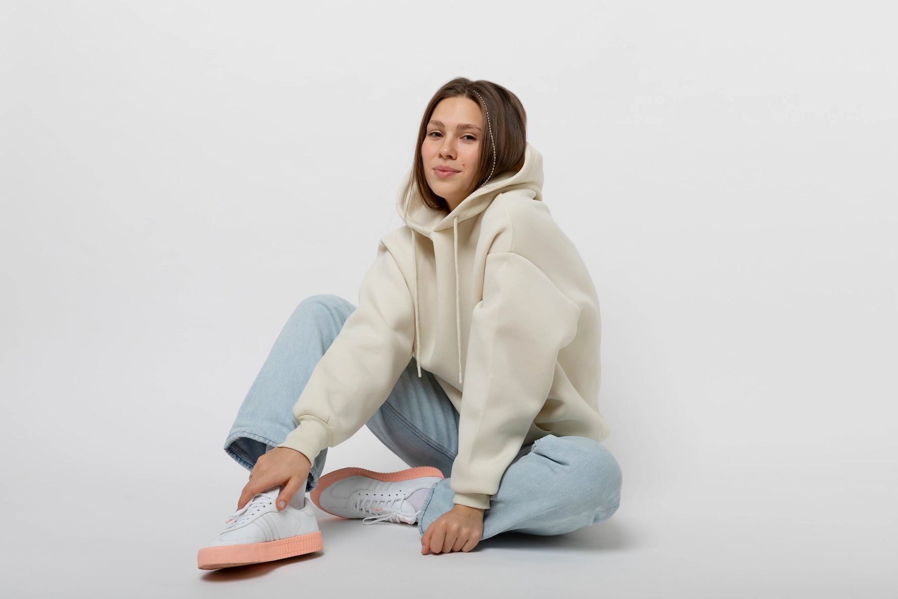 Vrouw die een comfortabele Wildfellow hoodie draagt in een ontspannen houding.